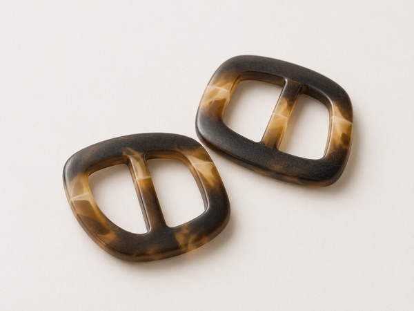 Assorted garment buckles in brass, silver, and gunmetal finishes.