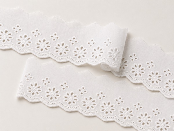 White English embroidery trim with eyelet cutwork and scalloped borders.