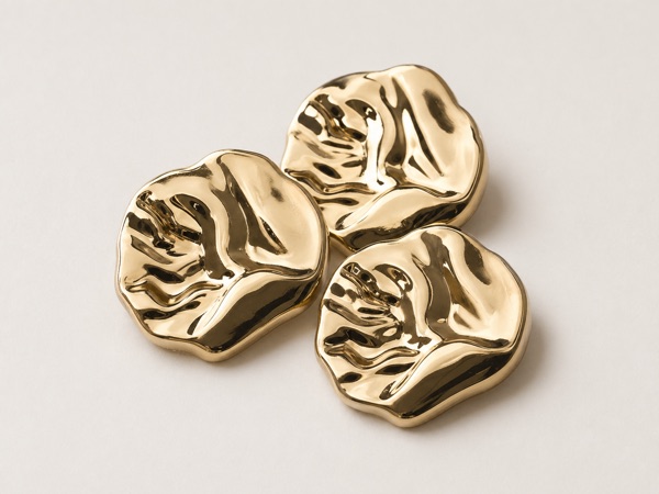 Metal apparel buttons in brass, pewter, and silver finishes.